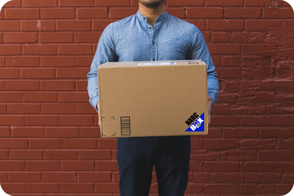 Man in front of a wall holding a box